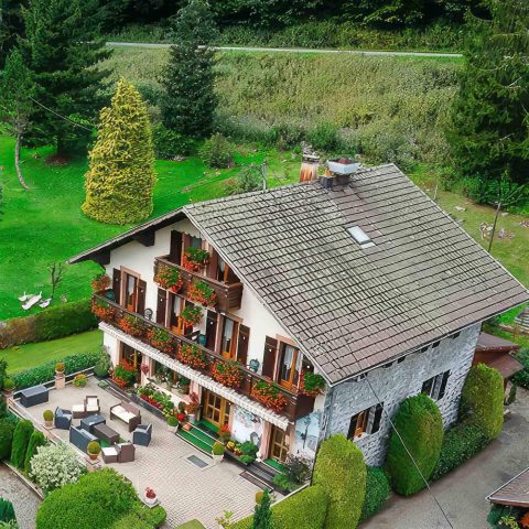 Photos aériennes capturées par drone d'une maison traditionnelle en pierre en Suisse.