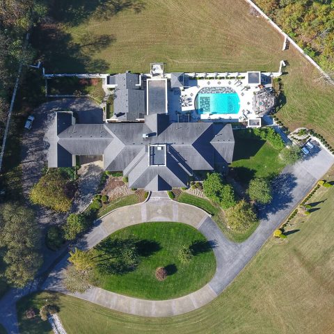 Vue aérienne d'une maison avec piscine capturée par un drone.