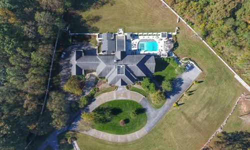 Vue aérienne d'une maison avec piscine capturée par un drone.