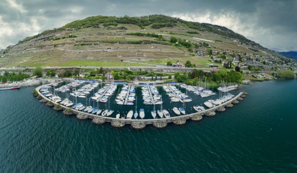 Vue aérienne d'un port avec un bateau à la forme arrondie, capturée par drone, présentée par Capture Immo.