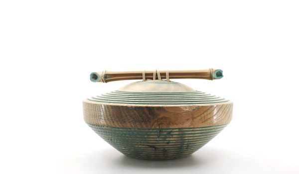 Photo sur fond blanc d'un bol japonais décoré avec un motif de bambou et un liseré bleu, évoquant la finesse et l'élégance de l'art japonais.